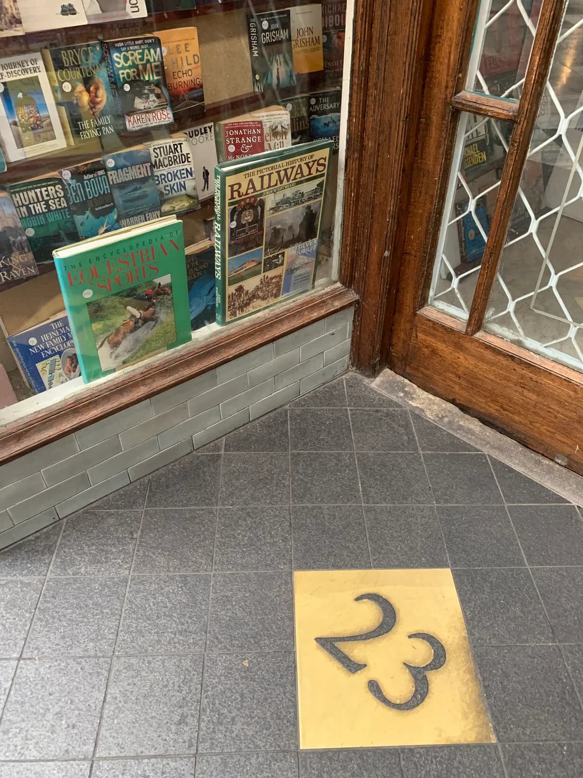 A yellow painted number 23 on the floor outside a secondhand bookshop in St Kevin's Arcade